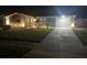 Well-lit front yard showcasing a single-story home with driveway and manicured lawn at night at 1144 Rushmore Dr, Holiday, FL 34690