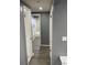 Hallway view leading to a modern gray and white bathroom with marble-patterned tile at 1144 Rushmore Dr, Holiday, FL 34690