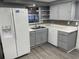 Bright kitchen featuring stainless steel refrigerator, sink, and gray cabinets and countertops at 1144 Rushmore Dr, Holiday, FL 34690