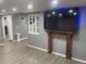 Cozy living room featuring a decorative fireplace and column accents, with wood flooring at 1144 Rushmore Dr, Holiday, FL 34690