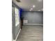 Modern gray living room with wood-look flooring, natural light, and television at 1144 Rushmore Dr, Holiday, FL 34690
