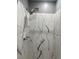 Shower featuring a modern rainfall shower head and black and white marble tiling at 1144 Rushmore Dr, Holiday, FL 34690