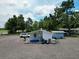 Aerial view of backyard with gravel, trees, and a white house and shed at 11907 Frontage Rd, Dade City, FL 33525