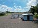 Aerial view of backyard with gravel, trees, and a white house and shed at 11907 Frontage Rd, Dade City, FL 33525