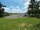 Aerial view of backyard with gravel, trees, and a white house and shed at 11907 Frontage Rd, Dade City, FL 33525