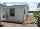 View of side and back of white house with gravel yard and chain link fence at 11907 Frontage Rd, Dade City, FL 33525