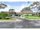 Charming community clubhouse featuring well-manicured landscaping, American flag, and easy access at 1250 S Pinellas Ave # 207, Tarpon Springs, FL 34689