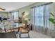 Inviting dining room featuring a glass table, neutral decor, and natural light from large windows at 1250 S Pinellas Ave # 207, Tarpon Springs, FL 34689