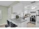 Bright condo kitchen with white cabinets, modern appliances, and a cozy breakfast bar at 1250 S Pinellas Ave # 207, Tarpon Springs, FL 34689