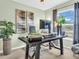 Bright home office with a modern desk, large monitor, and decorative plants at 1250 S Pinellas Ave # 207, Tarpon Springs, FL 34689