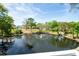 Scenic view of pond with fountain, surrounded by lush trees and blue sky at 1250 S Pinellas Ave # 207, Tarpon Springs, FL 34689