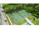 Aerial view of a community tennis court surrounded by lush greenery and mature trees at 1250 S Pinellas Ave # 207, Tarpon Springs, FL 34689