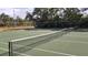 A fenced community tennis court ready for play on a sunny day at 1250 S Pinellas Ave # 207, Tarpon Springs, FL 34689