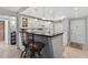 Bright kitchen with white cabinets, breakfast bar with chairs, and a tile backsplash at 12760 Indian Rocks Rd # 1049, Largo, FL 33774