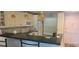 Bright kitchen featuring sleek black countertops, tile backsplash, and modern appliances under pendant lighting at 12760 Indian Rocks Rd # 1049, Largo, FL 33774