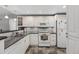 Well-lit kitchen featuring white appliances, ample counter space, and tiled floors at 12760 Indian Rocks Rd # 1049, Largo, FL 33774