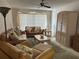 Living room features comfortable leather seating, a ceiling fan, and a large window at 12760 Indian Rocks Rd # 904, Largo, FL 33774