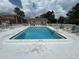Inviting community pool surrounded by lounge chairs, palm trees, and a clubhouse at 12760 Indian Rocks Rd # 904, Largo, FL 33774