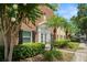 Brick building exterior featuring a white entrance and well-maintained landscaping with palm trees at 13684 Orange Sunset Dr # 101, Tampa, FL 33618