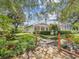 Serene backyard featuring lush landscaping, a stone pathway, fenced pool, and a charming pergola at 18803 Misty Shores Ln, Lutz, FL 33548