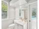Bright bathroom with large mirror, white vanity, and a door to the pool area at 18803 Misty Shores Ln, Lutz, FL 33548