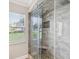 Modern shower with neutral tile, a built-in seat, and glass door at 18803 Misty Shores Ln, Lutz, FL 33548