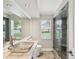Modern bathroom featuring a unique glass sink, a large mirror, and a glass-enclosed shower at 18803 Misty Shores Ln, Lutz, FL 33548