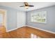 Bright bedroom with hardwood floors, shutters, a ceiling fan, and a closet at 18803 Misty Shores Ln, Lutz, FL 33548