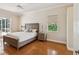 Cozy bedroom with a wood-frame bed, two side tables, and a large window at 18803 Misty Shores Ln, Lutz, FL 33548