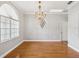 Dining room features a decorative chandelier, crown molding, a window, and wood floors at 18803 Misty Shores Ln, Lutz, FL 33548