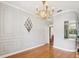 Dining room showcasing a decorative light fixture, crown molding and wood floors at 18803 Misty Shores Ln, Lutz, FL 33548