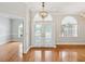 Elegant foyer featuring glass paneled double doors and hardwood floors at 18803 Misty Shores Ln, Lutz, FL 33548