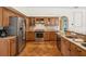 A well-appointed kitchen features stainless steel appliances and tan granite countertops and tile flooring at 18803 Misty Shores Ln, Lutz, FL 33548