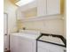 Functional laundry room with a washer, dryer, sink, and ample storage space at 18803 Misty Shores Ln, Lutz, FL 33548