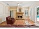 Cozy living room with a stone fireplace, ceiling fan and access to the outdoor pool area at 18803 Misty Shores Ln, Lutz, FL 33548