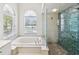 Large bathroom with a soaking tub, walk-in shower, and large windows at 18803 Misty Shores Ln, Lutz, FL 33548