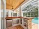 Outdoor kitchen area featuring a stainless steel refrigerator, and pool view at 18803 Misty Shores Ln, Lutz, FL 33548