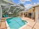 Outdoor pool area with an outdoor kitchen, screened in with comfortable seating at 18803 Misty Shores Ln, Lutz, FL 33548