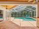 Screened-in pool area with brick patio and two blue Adirondack chairs at 18803 Misty Shores Ln, Lutz, FL 33548
