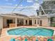 Backyard pool area featuring a large screened enclosure and ample patio space at 18803 Misty Shores Ln, Lutz, FL 33548
