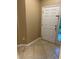 A welcoming entryway featuring tile flooring, beige walls, and a bright white paneled front door at 19239 Stone Hedge Dr, Tampa, FL 33647