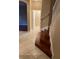 Hallway featuring tile flooring leading to a stairwell with hardwood steps and white railing at 19239 Stone Hedge Dr, Tampa, FL 33647