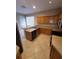Well-lit kitchen features wooden cabinets, tile floors, and a stainless steel sink at 19239 Stone Hedge Dr, Tampa, FL 33647