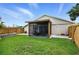 Spacious backyard featuring a covered screened-in patio, a grassy lawn, and wooden fencing for privacy at 2306 41St E St, Bradenton, FL 34208