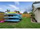 Backyard with colorful kayaks, wooden fencing, and a grassy lawn at 2306 41St E St, Bradenton, FL 34208