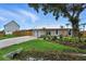 Single-story home featuring a metal roof, attached garage, lush landscaping, and a well-manicured lawn at 2306 41St E St, Bradenton, FL 34208