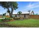 Charming single-story home featuring a metal roof, lush landscaping, and mature trees in a serene neighborhood at 2306 41St E St, Bradenton, FL 34208