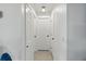 Hallway view with multiple white doors and speckled floor, illuminated by a ceiling light at 2306 41St E St, Bradenton, FL 34208