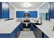 Well-appointed kitchen featuring blue cabinets, quartz countertops, modern appliances, and ample storage space at 2306 41St E St, Bradenton, FL 34208