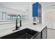 Bright kitchen featuring blue cabinets, sleek countertops, modern fixtures, and open view to the outside at 2306 41St E St, Bradenton, FL 34208